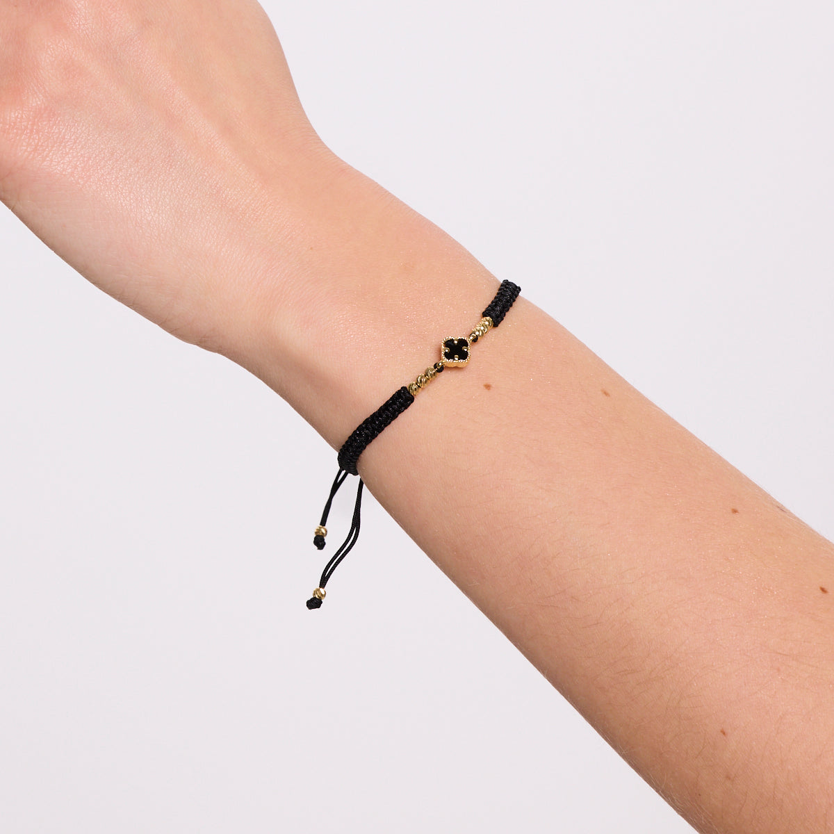 Bransoletka złota na czarnym sznurku z onyksem - koniczyna
